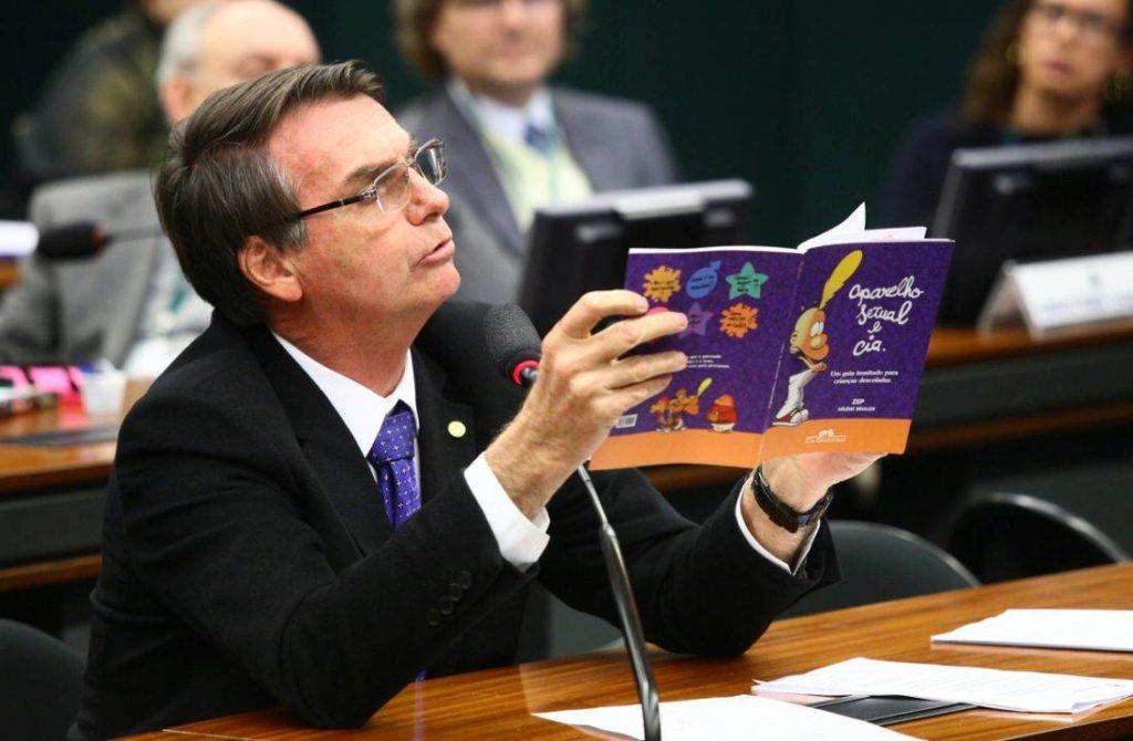 O então deputado Jair Bolsonaro exibe material do governo federal que ele chamava de 'kit gay'