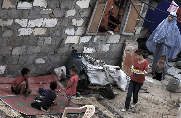 Membros de uma família palestina em casa destruída durante o conflito Israel-Gaza.