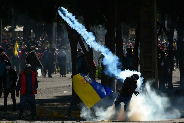 Manifestante joga gás lacrimogêneo contra policiais durante confronto na área do parque El Arbolito, em Quito no Equador, em 22/06/2022.