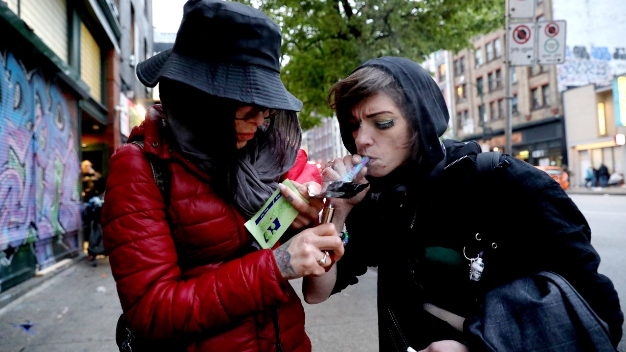 VANCOUVER, BRITISH COLUMBIA - MAY 03: Shyan Willow, 27, left, and Kia Haim, 39, smoke fentanyl along East Hastings Street in the Downtown Eastside (DTES) neighborhood on Tuesday, May 3, 2022 in Vancouver, British Columbia. Supervised consumption sites in the DTES give addicts who use fentanyl, opioids, crystal methamphetamine and other drugs a place to use and get harm reduction supplies; clean syringes, alcohol swabs, sterile water, tourniquets, spoons and filters. On April 14, 2016, provincial health officer Dr. Perry Kendall declared a public health emergency under the Public Health Act due to the significant rise in opioid-related overdose deaths reported in B.C. since the beginning of 2016. (Gary Coronado / Los Angeles Times via Getty Images)