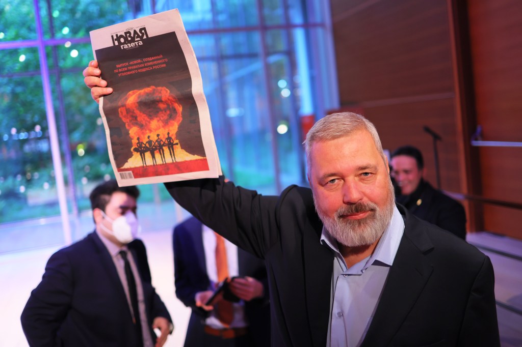 Vencedor do Nobel da Paz em 2021, Dmitry Muratov mostra o jornal Novaya Gazeta durante premiação