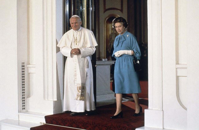 O papa João Paulo II caminha com a rainha britânica Elizabeth II no Palácio de Buckingham, em Londres. 28/05/1982.