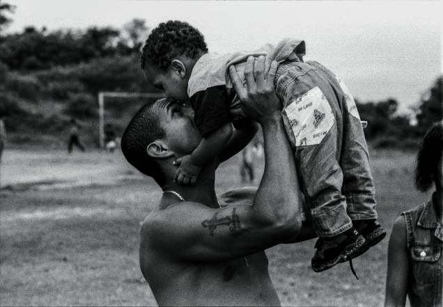 O rapper Mano Brown com o filho Jorge nos braços, anos 90.