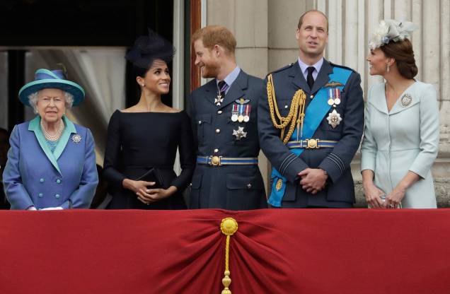 A rainha britânica Elizabeth II  ,Meghan, a duquesa de Sussex, o príncipe Harry, o príncipe William e Kate, a duquesa de Cambridge, observam um sobrevôo de aeronaves da Royal Air Force passarem sobre o Palácio de Buckingham em Londres, 10/07/2018.