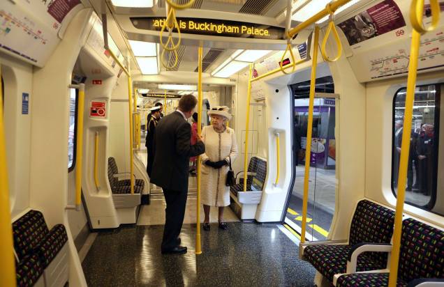 A rainha Elizabeth da Grã-Bretanha fala com um funcionário enquanto inspeciona um metrô durante sua visita à estação de Baker Street, em Londres, em 20 /03/2013.