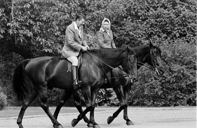 O presidente dos EUA Ronald Reagan e a rainha britânica Elizabeth II, andam `a cavalo nos terrenos do Castelo de Windsor, na Inglaterra. 02/06/1982.