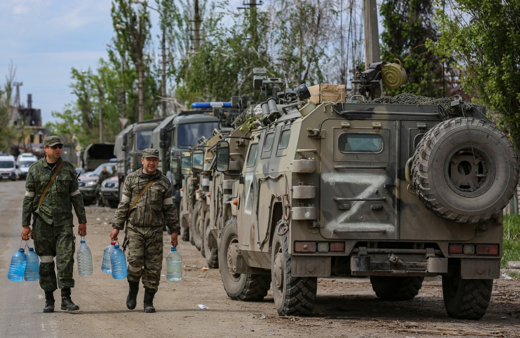 Mariupol (Ucrânia), 17/05/2022.- A autoproclamada milícia da República Popular de Donetsk (DPR) carrega garrafas de água enquanto a evacuação de militares ucranianos está sendo preparada da siderúrgica Azovstal