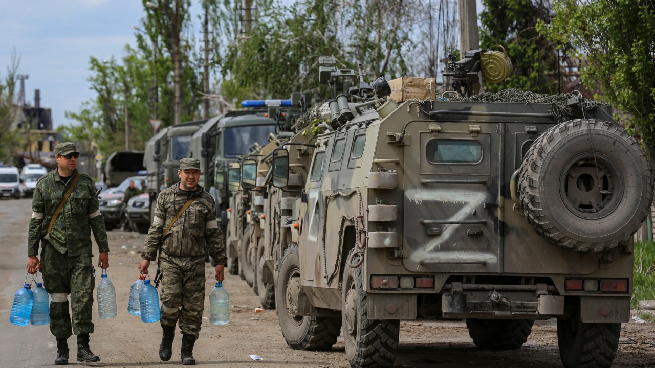 Mariupol (Ucrânia), 17/05/2022.- A autoproclamada milícia da República Popular de Donetsk (DPR) carrega garrafas de água enquanto a evacuação de militares ucranianos está sendo preparada da siderúrgica Azovstal