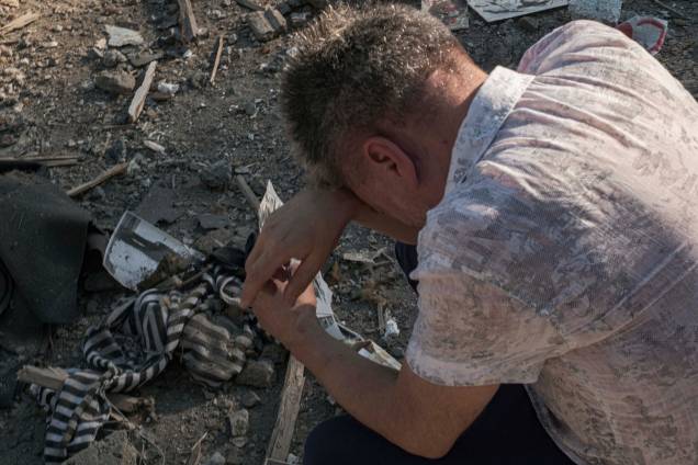 Um homem lamenta as perdas sobre os escombros de um edifício residencial destruído após bombardeio em uma área residencial em Mykolaiv, sul da Ucrânia, 29/06/2022.