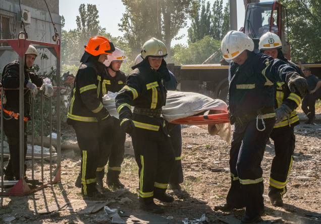 Equipes de resgate ucranianas carregam um corpo, vítima dos bombardeios russos em uma área residencial em Mykolaiv, sul da Ucrânia, 29/06/2022.