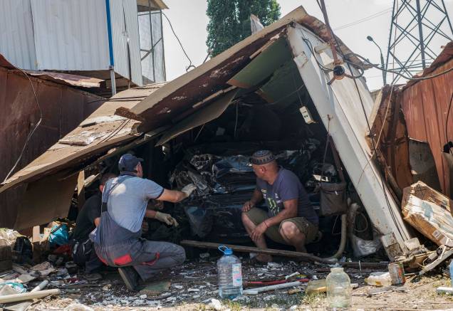 Homens examinam os destroços de um carro após bombardeio russo, em uma área residencial em Mykolaiv, sul da Ucrânia, 29/06/2022.