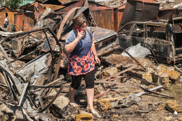Uma mulher caminha nos escombros de residências destruídas, após bombardeio em uma área residencial em Mykolaiv, sul da Ucrânia, 29/06/2022.