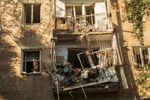 Um homem próximo de uma janela dentro de seu apartamento danificado, após bombardeio russo em uma área residencial em Mykolaiv, sul da Ucrânia, 29/06/2022.