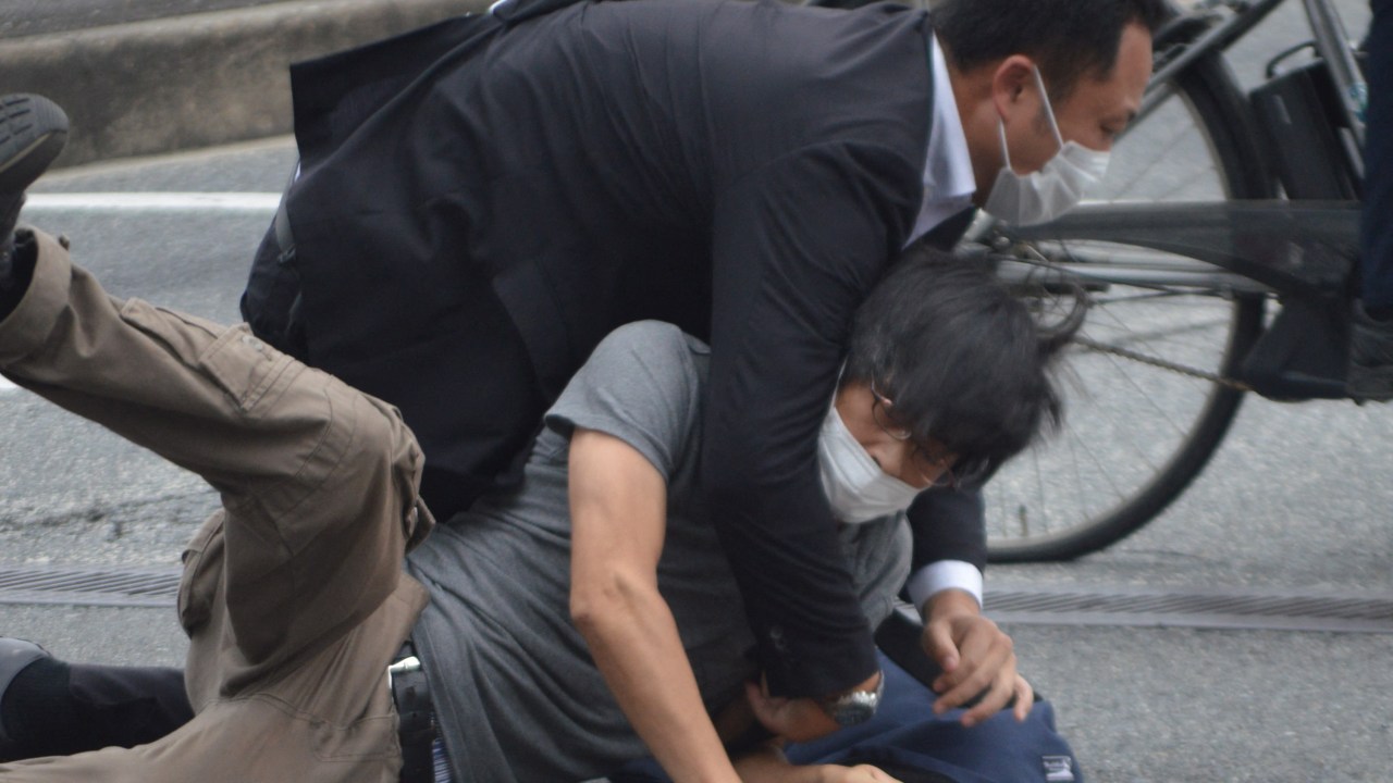 A man (bottom) suspected of shooting former Japanese prime minister Shinzo Abe is tackled to the ground by police at Yamato Saidaiji Station in the city of Nara on July 8, 2022. - Shinzo Abe was shot at a campaign event on July 8, a government spokesman said, as local media reported the nation's longest-serving premier was showing no vital signs. (Photo by Yomiuri Shimbun / AFP) / Japan OUT / NO ARCHIVES