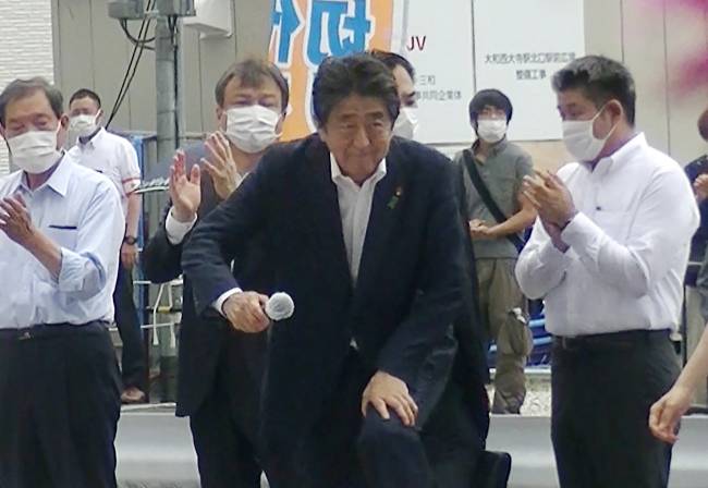 JAPAN-POLITICS-ATTACK-ABE This image taken from video provided by witness Toshiharu Otani and released via Jiji Press shows former Japanese prime minister Shinzo Abe (C) attending an election campaign before giving a speech at Kintetsu Yamato-Saidaiji station square in Nara, while a man (2nd R-behind) suspected of shooting Abe shortly after stands in the background. - Japan's former prime minister Shinzo Abe has been confirmed dead after he was shot at a campaign event in the city of Nara on July 8, 2022, public broadcaster NHK and Jiji news agency reported. (Photo by Toshiharu Otani / JIJI PRESS / AFP) / - Japan OUT / -----EDITORS NOTE --- RESTRICTED TO EDITORIAL USE - MANDATORY CREDIT