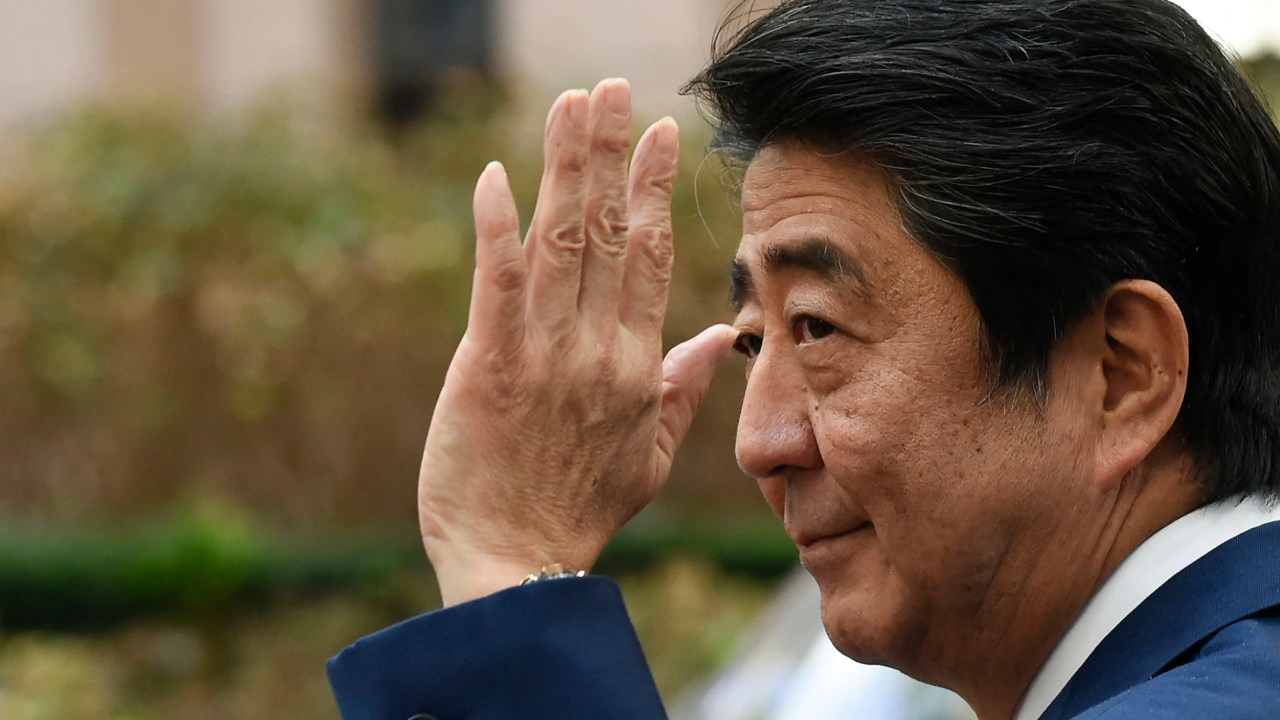 (FILES) In this file photo taken on October 19, 2018 Japan's Prime Minister Shinzo Abe waves as he leaves after attending an EU - Korea Summit meeting at the European Council in Brussels. - Abe has been confirmed dead after he was shot at a campaign event in the city of Nara on July 8, 2022, public broadcaster NHK and Jiji news agency reported. (Photo by JOHN THYS / AFP)