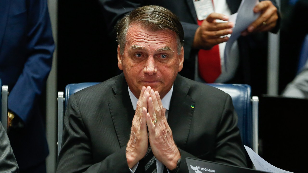 Brazilian President Jair Bolsonaro gestures during a session of the National Congress to enact amendments of the Constitution to increase social benefits in Brasilia, on July 14, 2022. (Photo by Sergio Lima / AFP)