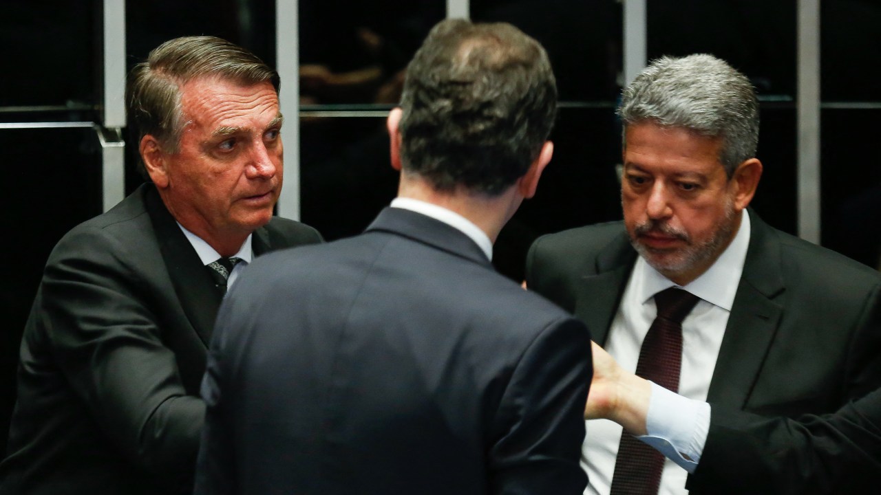 Brazilian President Jair Bolsonaro (L), President of the Chamber of Deputies Arthur Lira (R) and Senator Rodrigo Pacheco (C) are pictured before a session of the National Congress to enact amendments of the Constitution to increase social benefits in Brasilia, on July 14, 2022. (Photo by Sergio Lima / AFP)
