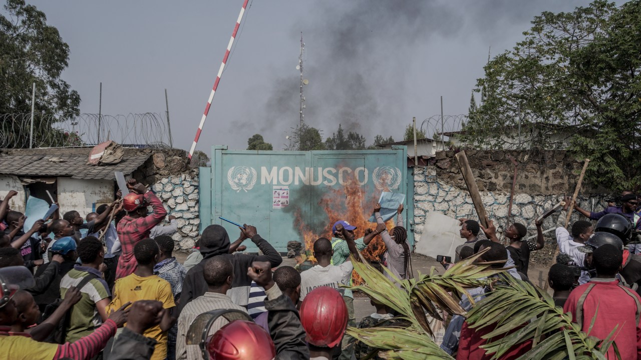 Manifestantes atearam fogo em frente à sede da Missão das Nações Unidas para a Estabilização do Congo (MONUSCO) em Goma, em 25 de julho de 2022. - Manifestantes invadiram uma base das Nações Unidas na cidade congolesa de Goma na segunda-feira, disse um jornalista da AFP, exigindo a saída das forças de paz da região. Centenas de pessoas bloquearam estradas e gritaram slogans anti-ONU antes de invadir a sede da missão de paz da ONU em Goma, bem como uma base logística nos arredores da cidade. (Foto por GLODY MURHABAZI/AFP)