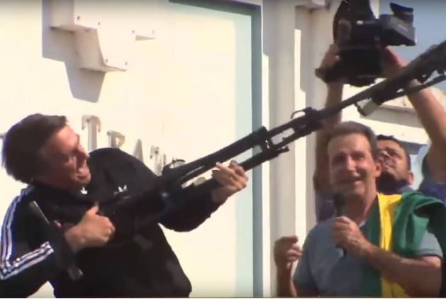 O então candidato a presidente pelo PSL, Jair Bolsonaro, simula um fuzil com um tripé durante evento em Rio Branco (AC) //
