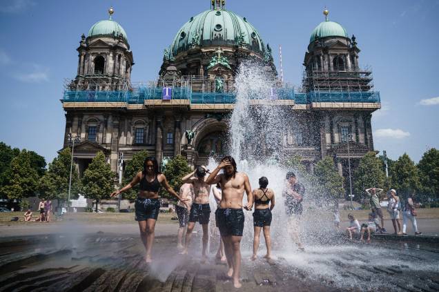 Turistas se refrescam em uma fonte no parque Lustgarten em Berlim, Alemanha, 19/06/2022.