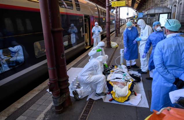 Equipe médica carrega um paciente infectado com COVID-19 a bordo de um trem de alta velocidade TGV, na estação ferroviária de Estrasburgo, leste da França, em 03/04/2020.