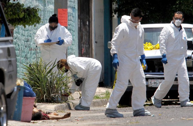 Peritos forenses trabalham ao lado de um cadáver, vítima do novo coronavírus, no bairro Lopez Portillo, em Guadalajara, México, 03/05/2020.