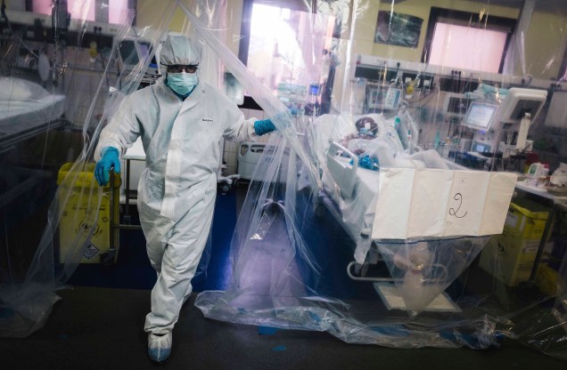 Um membro da equipe médica sai de uma sala protegida por uma lona transparente após cuidar de um paciente infectado com COVID-19 na unidade de terapia intensiva do hospital Franco-Britannique em Levallois- Perret, norte de Paris. 10/05/2020