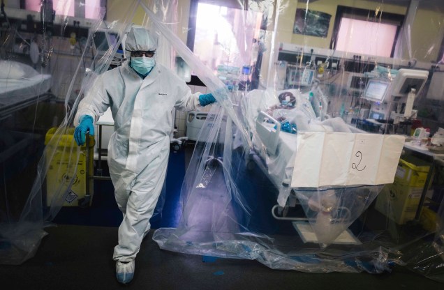 Um membro da equipe médica sai de uma sala protegida por uma lona transparente após cuidar de um paciente infectado com COVID-19 na unidade de terapia intensiva do hospital Franco-Britannique em Levallois- Perret, norte de Paris. 10/05/2020 Um membro da equipe médica sai de uma sala protegida por uma lona transparente após cuidar de um paciente infectado com COVID-19 na unidade de terapia intensiva do hospital Franco-Britannique em Levallois- Perret, norte de Paris. 10/05/2020