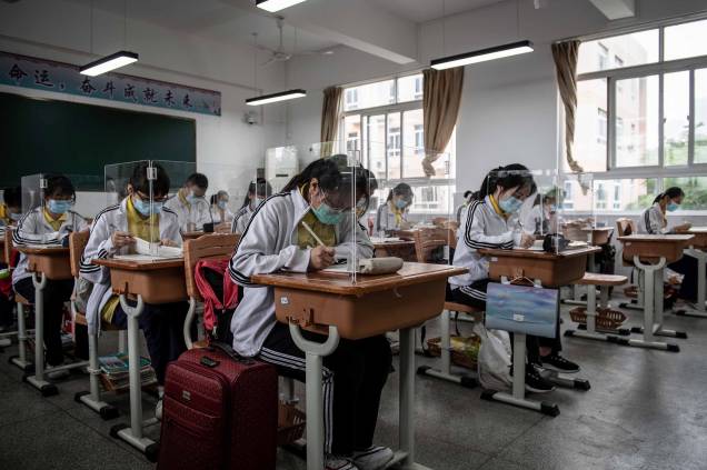 Alunos do ensino médio estudam com divisórias de plástico em uma sala de aula em Wuhan, na província central de Hubei, na China, cidade que se iniciou da pandemia de coronavírus, 06/05/2020.