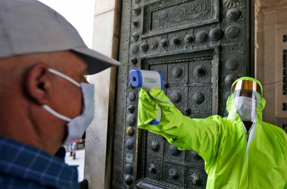 Um médico verifica a temperatura de um fiel sírio antes de entrar na Mesquita Omíada em Damasco, 15/05/2020.