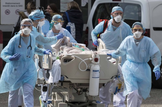 A equipe médica transporta um paciente com Covid-19, para um helicóptero médico no Hospital Emile Muller em Mulhouse, leste da França, em 22/03/2020.