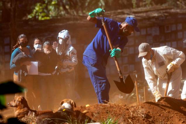 Parentes choram enquanto assistem aos trabalhadores do cemitério jogar terra sobre o caixão de um parênte, que morreu de COVID-19, no cemitério Vila Formosa em São Paulo, Brasil,  28/05/2020.