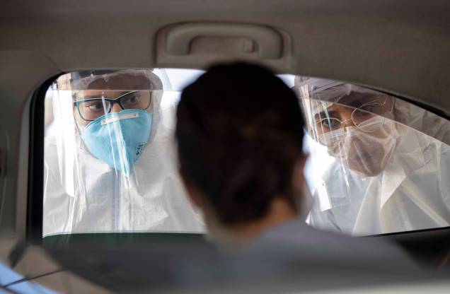Equipe médica verifica as pessoas dentro de seus carros para descobrir se têm sintomas de COVID-19 em Guarulhos, São Paulo, Brasil,  30/03/2020.