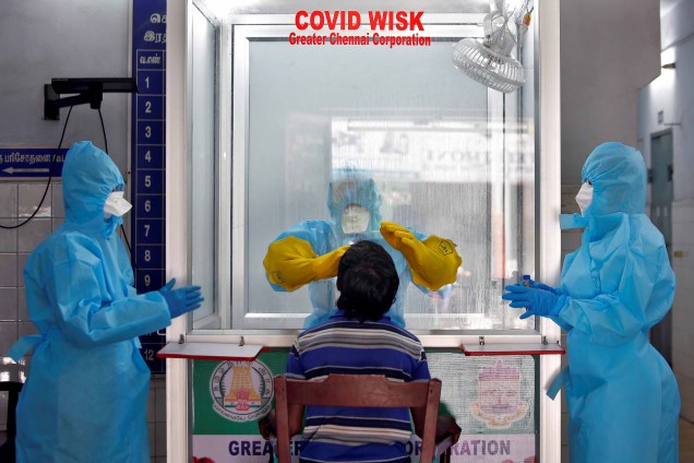 Um médico em uma câmara de proteção pega um cotonete de um homem para testar a doença de coronavírus (COVID-19), em Chennai, Índia, 13/04/2020. Um médico em uma câmara de proteção pega um cotonete de um homem para testar a doença de coronavírus (COVID-19), em Chennai, Índia, 13/04/2020.