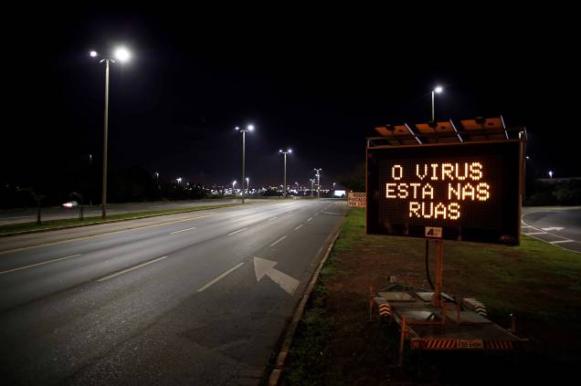 Placa com mensagem alertando sobre vírus está na rua é vista em avenida vazia, em meio ao surto de doença por coronavírus (COVID-19), em Brasília, 07/04/2020.