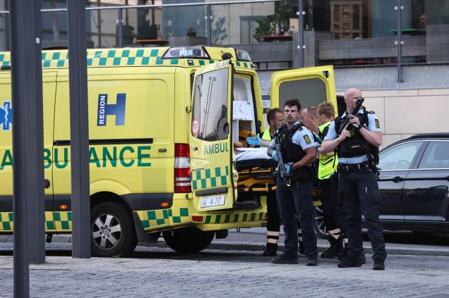 Uma ambulância e policiais armados na evacuação de pessoas no shopping Fields em Copenhague, Dinamarca, após um homem efetuar vários disparos contra pessoas, deixando mortos e feridos, em 03/07/2022. 
