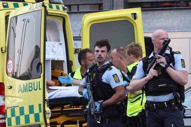 Uma ambulância e policiais armados na evacuação de pessoas no shopping Fields em Copenhague, Dinamarca, após um homem efetuar vários disparos contra pessoas, deixando mortos e feridos, em 03/07/2022.
