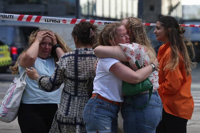 Pessoas se abraçam enquanto a polícia evacua o shopping Fields em Copenhague, Dinamarca, em 03/07/2022, após um atirador efetuar vários disparos, deixando mortos e feridos  feridos.