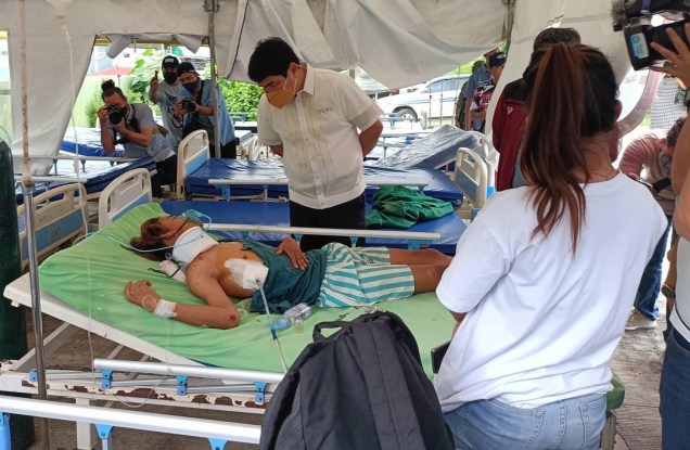 Secretário do Departamento de Bem-Estar e Desenvolvimento Social (DSWD), Irwin Tulfo (C), visitando uma vítima em um hospital improvisado após um terremoto em Bangued, província de Abra, Filipinas, 27/07/2022.