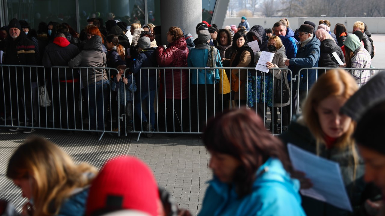 People fleeing from Ukraine wait in a line outside Tauron Arena sports hall where registration point for National Identification Number is opened, in Krakow, Poland on March 16, 2022. Tens of thousends Ukrainian refugees come to Poland due Russian invasion and from March 16 they can register in the Polish national PESEL identification number system. (Photo by Jakub Porzycki/NurPhoto via Getty Images)