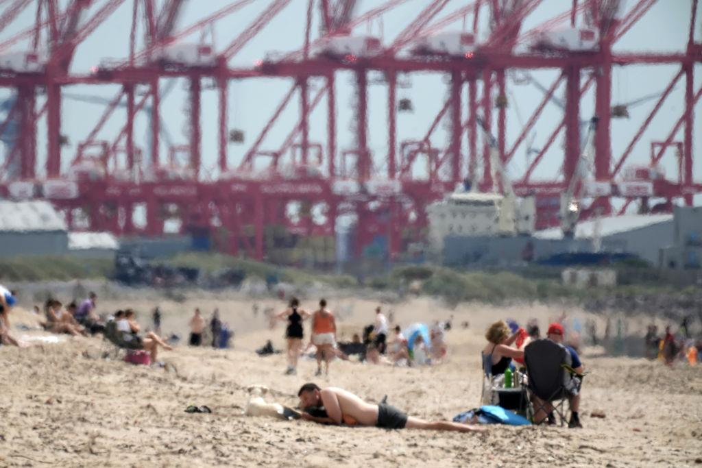 LIVERPOOL, UNITED KINGDOM - JULY 11: A heat haze shimmers over Crosby Beach as people relax in the warm weather on July 11, 2022 in Liverpool, United Kingdom. Britain will experience a heatwave this week as temperatures in some parts are expected to reach 30c. A level 2 heat health wave has been issued of the south and eastenr parts of England. (Photo by Christopher Furlong/Getty Images)