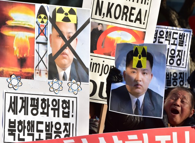 Ativistas sul-coreanos gritam slogans com cartazes mostrando retratos do líder norte-coreano Kim Jong-Un durante uma manifestação denunciando o teste da bomba de hidrogênio da Coreia do Norte, em Seul em 7 de janeiro de 2016.