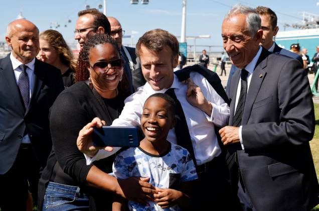 O presidente da França Emmanuel Macron (C) e o presidente de Portugal Marcelo Rebelo de Sousa (D) tiram uma selfie com turistas enquanto caminham para o Oceanário de Lisboa, como parte da Conferência do Oceano da ONU, em 30/06/2022.