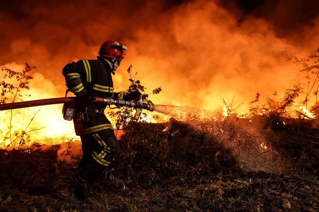 Um bombeiro apoiado por bombeiros táticos (invisíveis) ateou fogo controlado para queimar um pedaço de terra enquanto tentava impedir que o fogo se espalhasse devido à mudança do vento, enquanto lutavam contra um incêndio florestal perto de Louchats em Gironde, sudoeste da França, em 17 de julho de 2022. - A França estava em alerta máximo em 18 de julho de 2022, quando o pico de uma onda de calor castigava o país, enquanto os incêndios florestais em partes do sudoeste da Europa não mostravam sinais de diminuir. Na região sudoeste do Gironde, os bombeiros durante o fim de semana continuaram lutando para controlar as chamas florestais que devoraram quase 11.000 hectares (27.000 acres) desde 12 de julho. (Foto de THIBAUD MORITZ / AFP)