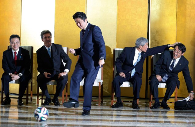 O ex primeiro-ministro do Japão, Shinzo Abe, chuta uma bola de futebol durante encontro com jogadores brasileiros em Brasília, 01/08/2014.