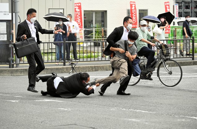 A polícia de segurança aborda um suspeito de ter atirado no ex-primeiro-ministro Shinzo Abe do lado de fora da estação Yamato-Saidaiji em Nara, Japão, 08/07/2022. O suspeito identificado como Tetsuya Yamagami foi preso e levado sob custódia.