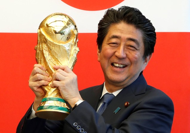 O ex primeiro ministro japonês, Shinzo Abe, com o troféu do Mundial da FIFA, promovendo o próximo mundial de futebol, 27/04/2018.
