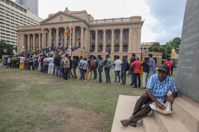 Pessoas fazem fila por comida em frente ao secretariado do Presidente em Colombo, Sri Lanka, 10/07/2022, um dia após as residências oficiais terem sido invadidas. O presidente e o primeiro-ministro do Sri Lanka concordaram em renunciar ao governo do país.