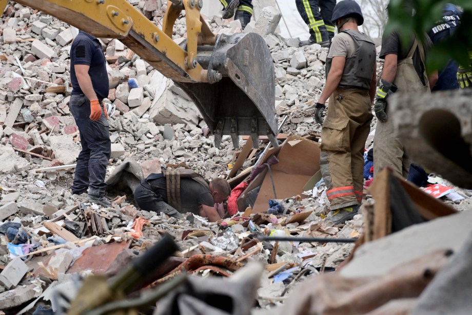 Bombeiros vasculham nos escombros vítimas, depois que um prédio foi parcialmente destruído após um bombardeio, em Chasiv Yar, leste da Ucrânia, em 10/07/2022.